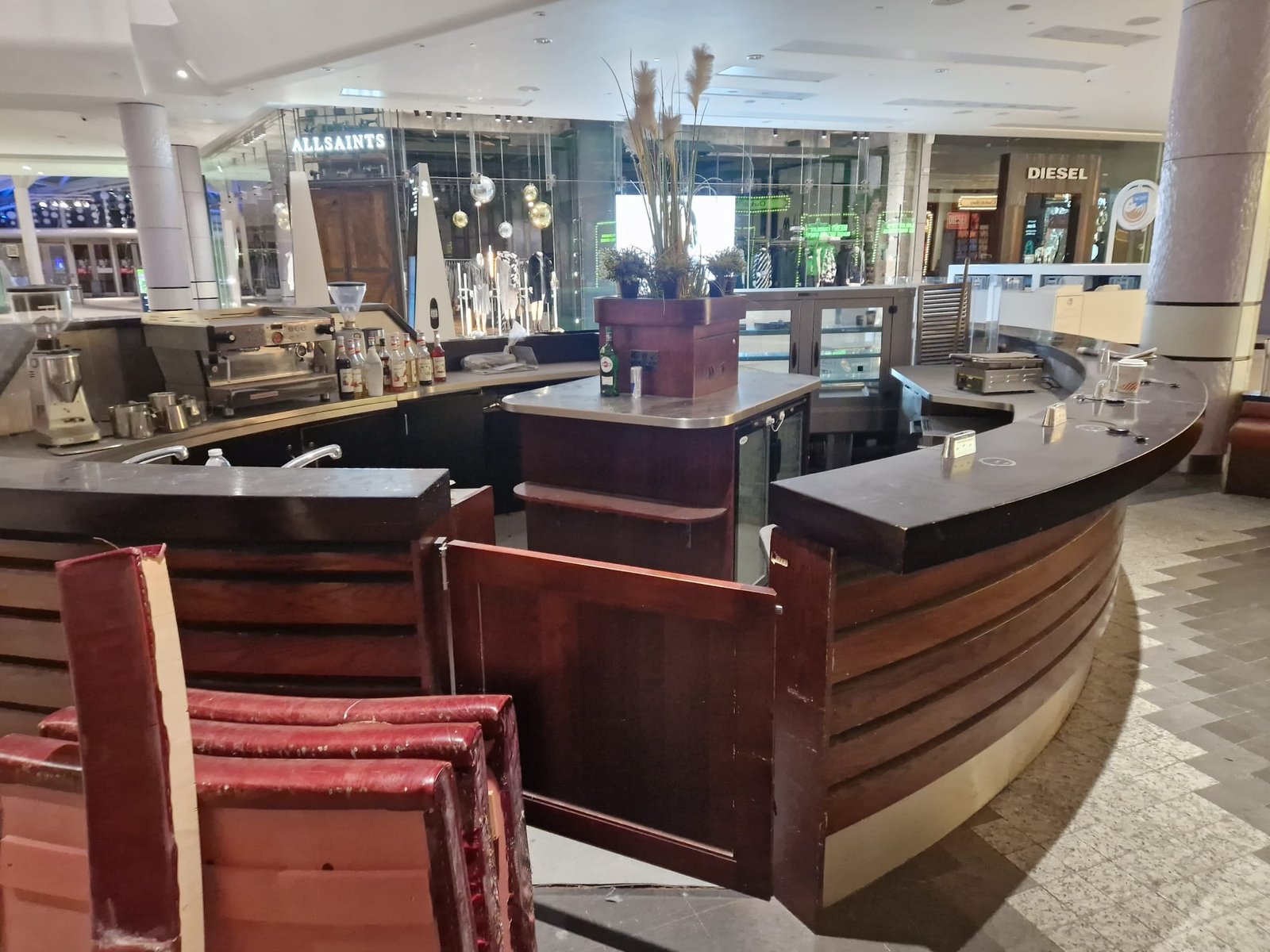 Dismantled curved kiosk frame with tools on the mall floor