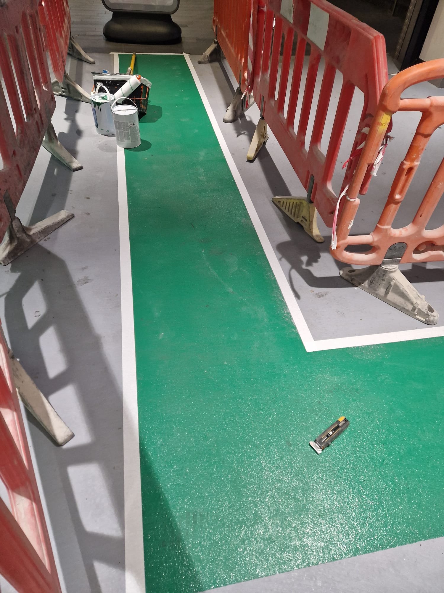 Completed green pedestrian walkway between barriers