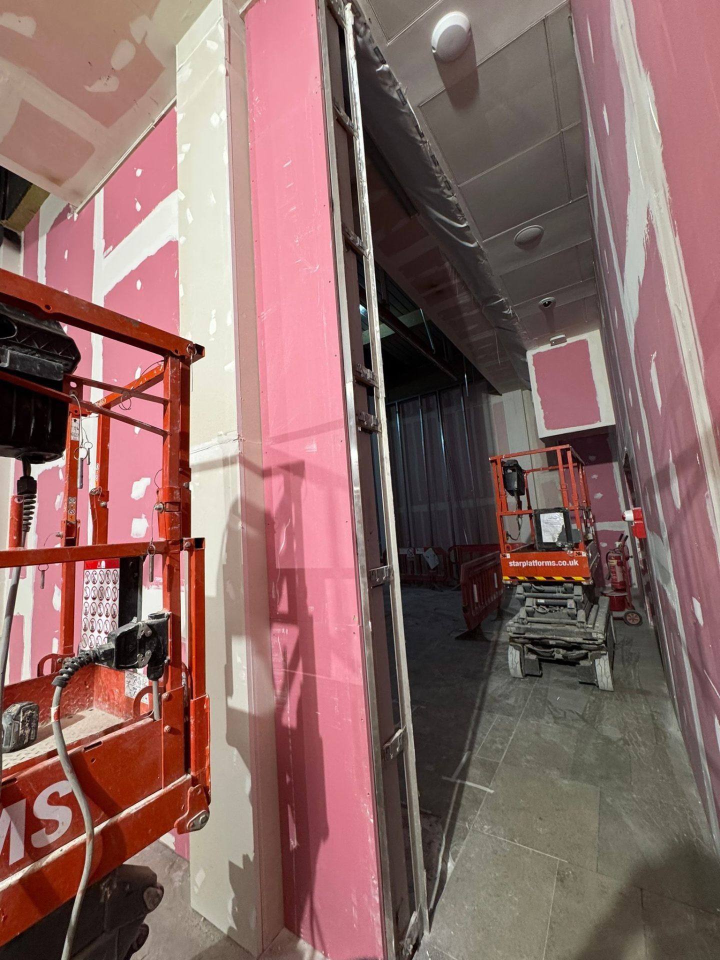 Fire-rated pink plasterboard partitions around doorway