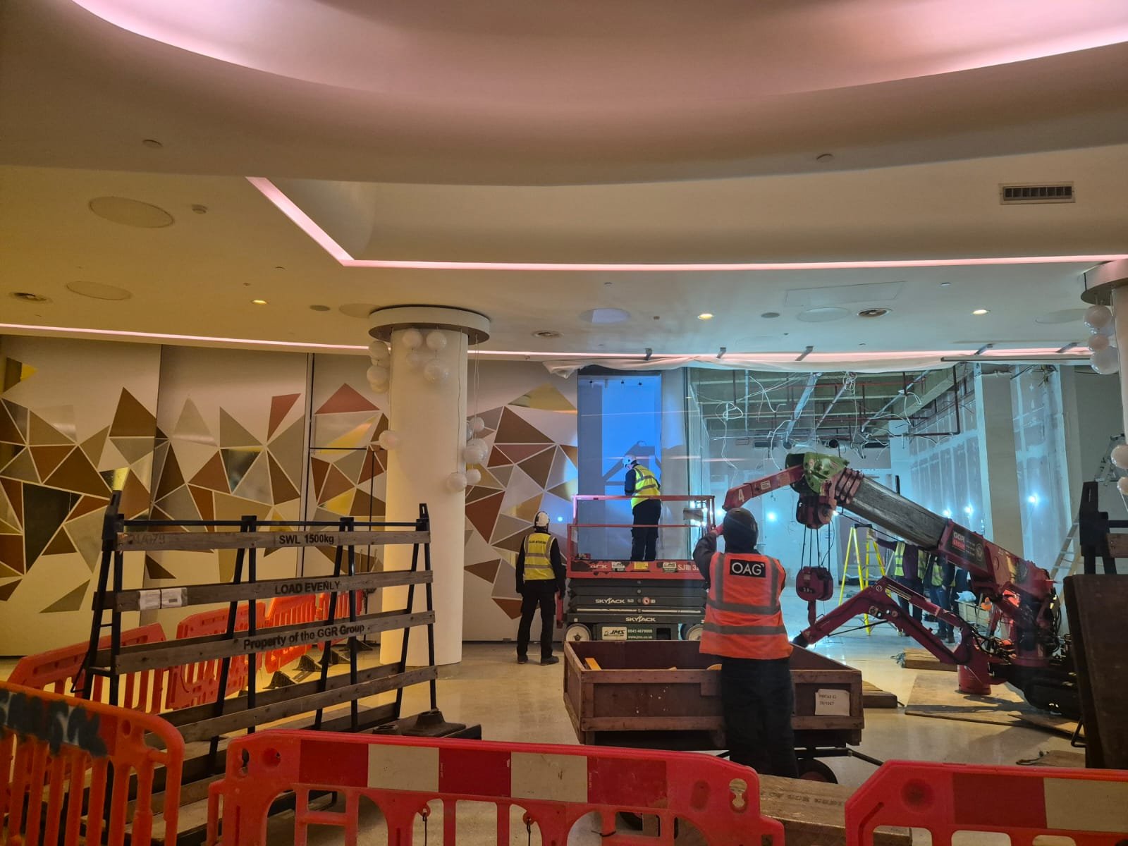 Mall-side view of live works behind protective sheeting