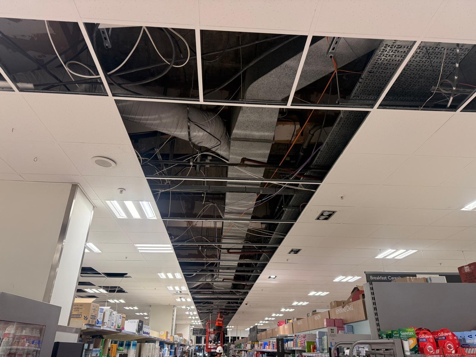 Removed tiles revealing insulated ductwork above OFFERS aisle